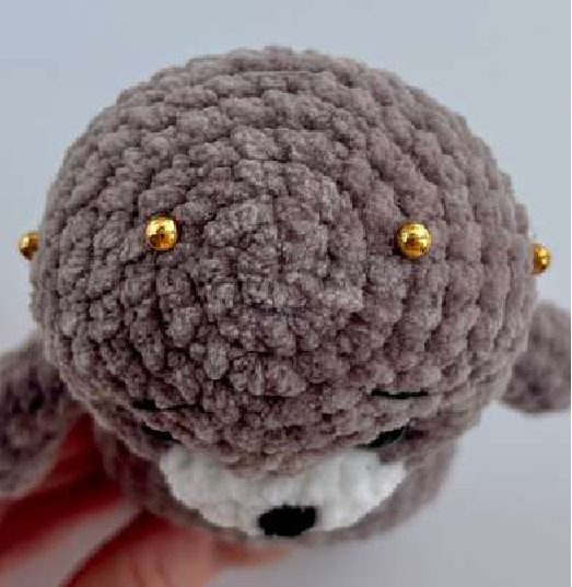 Close-up of bear face with embroidered nose, eyes, and eyebrows