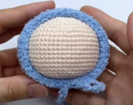 Crocheting the body of the toy after joining the legs.