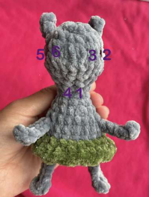 Embroidering the face details like nostrils and eyebrows.