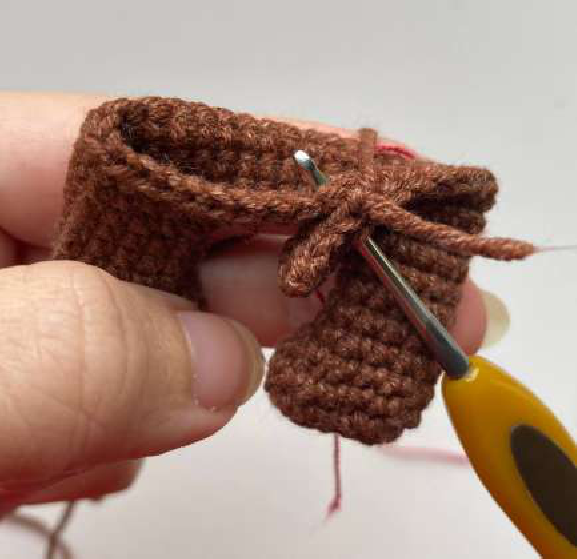 Two crocheted legs joined together with chains, forming the base of the body