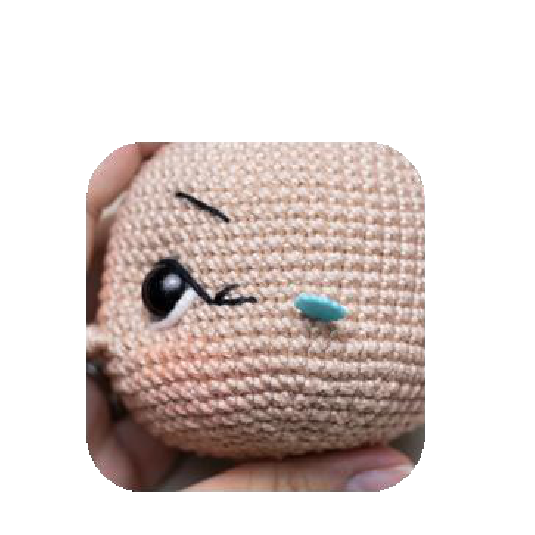 Sewing the first ear onto the doll