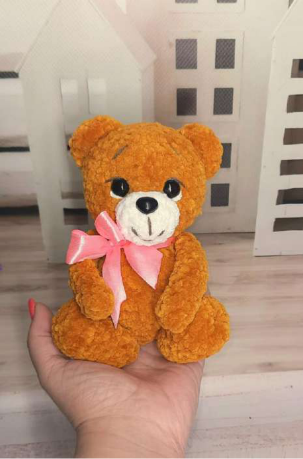 Finished crochet plush teddy bear holding a red heart.