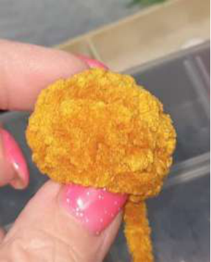 Sewing the ears onto the top of the bear's head.