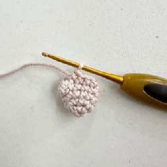 Hands attaching the crocheted clamp around a wooden ring